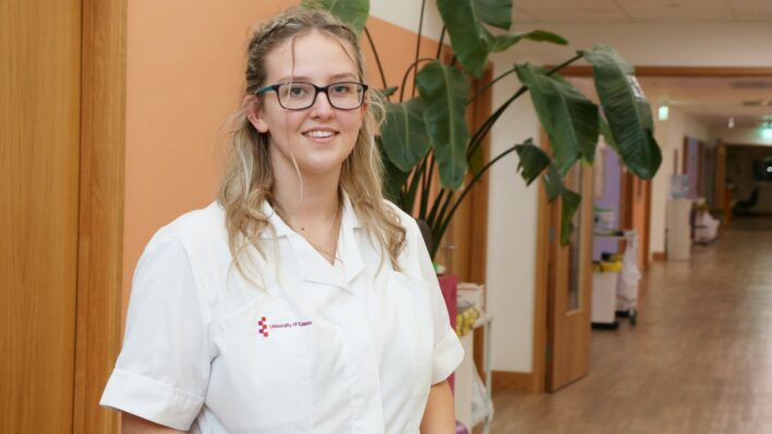 Female wearing a white OT uniform standing in the corridor at Arthur Rank Hospice