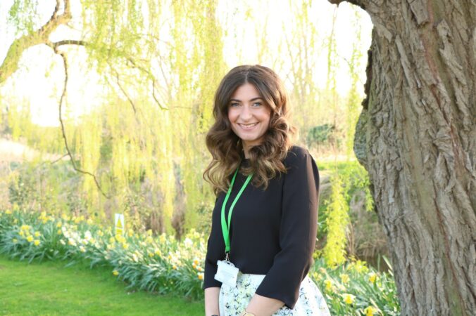Female smiling in the garden with yellow daffodils