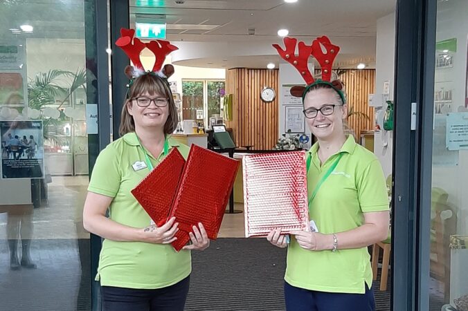 Community fundraisers Alison and Sarah wearing their green Charity t-shirts and reindeer antlers!
