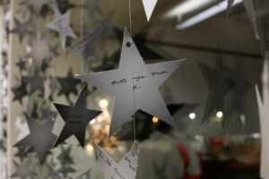 Cardboard white stars hung - says Miss you Mum 