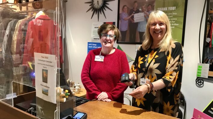 Two smiley female colleagues stand behind the till at our Cottenham shop