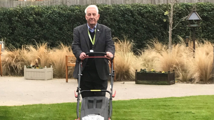 Mick with lawnmower on the 'newly striped' lawn