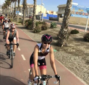 Female cyclist cycling with other cyclists in Spain