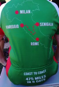 Back of someone wearing a green and read cycling outfit with coast to coast in Italy on it. 