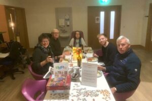 Judy, her husband Neil, and family members enjoy a family supper