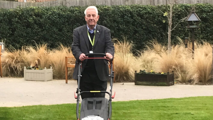 Mick, volunteer gardener cuts the grass at Arthur Rank Hospice