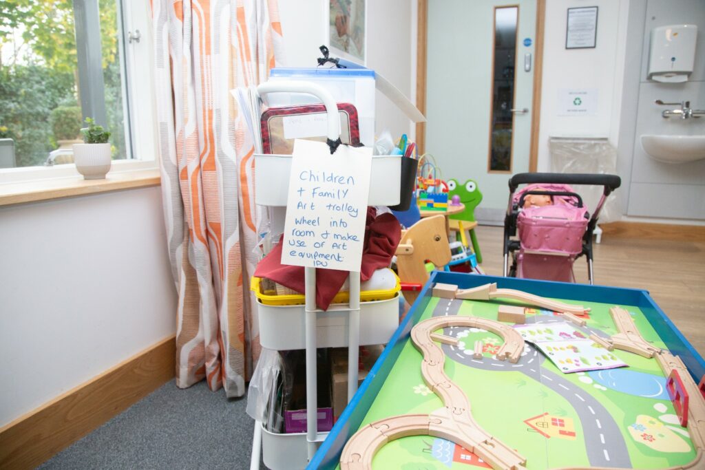 White trolley and childrens train set and pink dolls pram