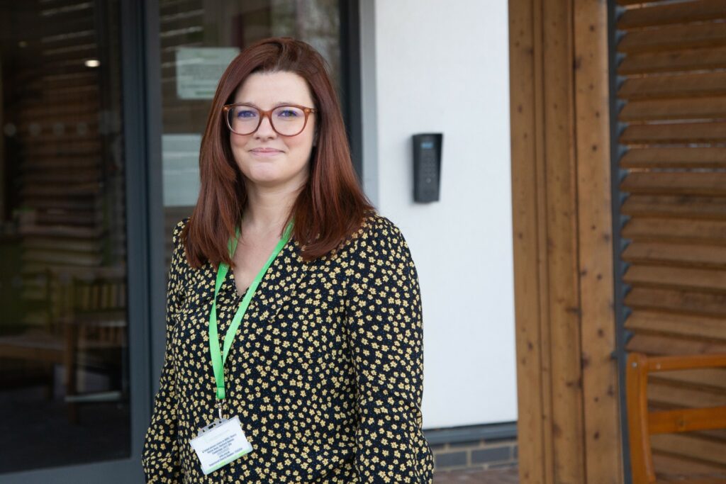 Female wearing green lanyard and green blouse smiling at the camera