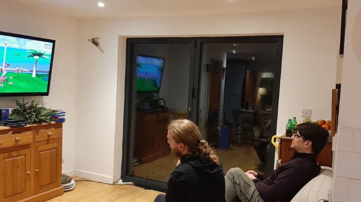 two males in black tops playing video a game