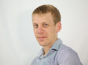Male facing the camera wearing a blue and white shirt