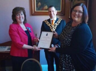 2 females and mayor holding award