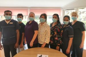 Seven Health Professionals standing in a row wearing masks