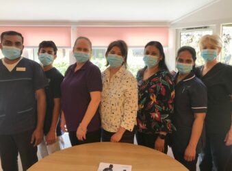 Seven Health Professionals standing in a row wearing masks