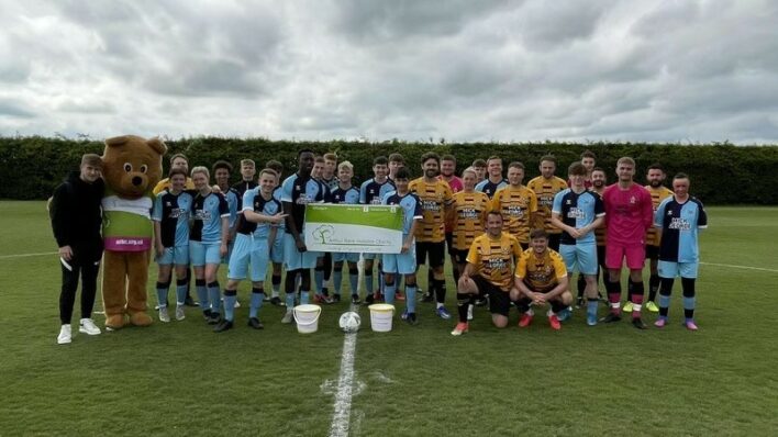 Males in football kits posing for a team photo
