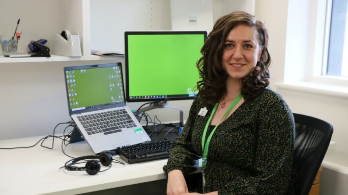 Female looking at the camera in front of a computer