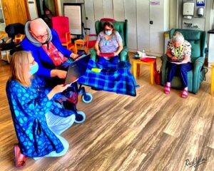 People in chairs in a room looking at ipads