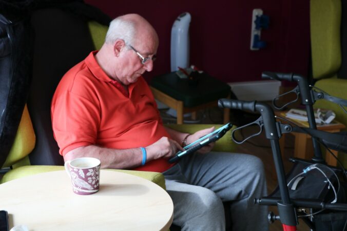 Male sitting in a chair looking at an ipad