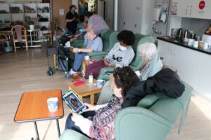 People sitting in chairs looking at ipads 