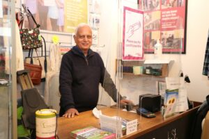 Male standing behind a shop counter