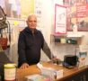 Male standing behind a shop counter