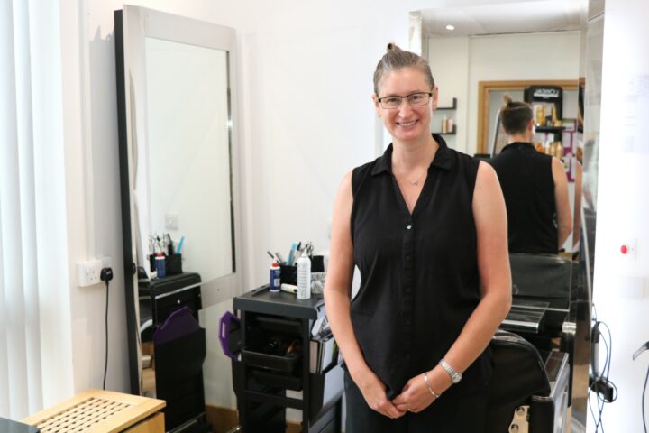 Female wearing glasses and black top smiling at camera