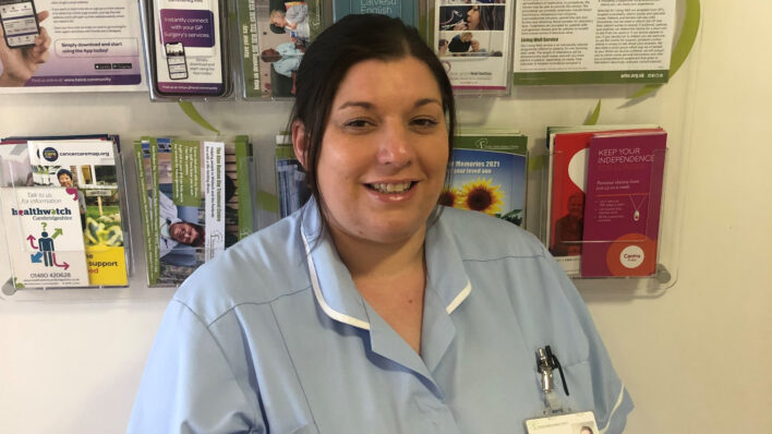Female nurse in a blue uniform smiling