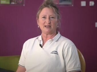 Female wearing a white uniform looking at the camera