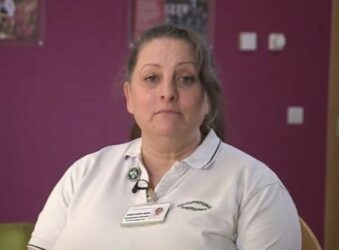 Female wearing a white polo shirt looking at the camera