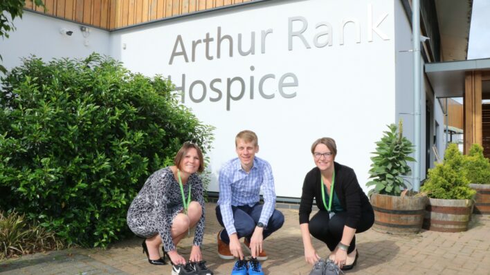 2 women and 1 man trainers Arthur Rank Hospice Charity sign