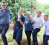 Male and 4 females wearing clinical uniforms smile to the camera