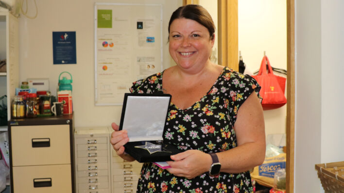 Female holding a black and white box with a star medal
