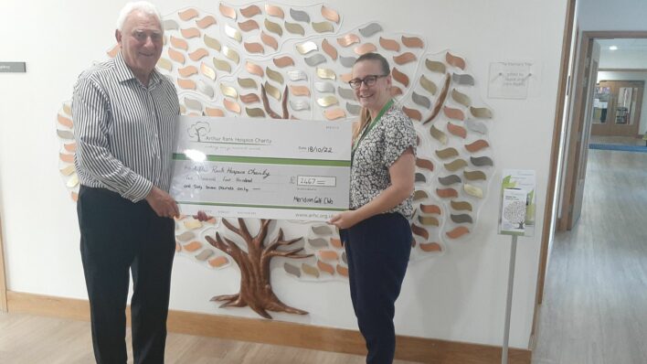 Male and female holding a large cheque