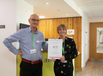 Male and female holding a certificate and looking at the camera