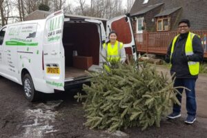 White van and male and female with a real Christmas Tree