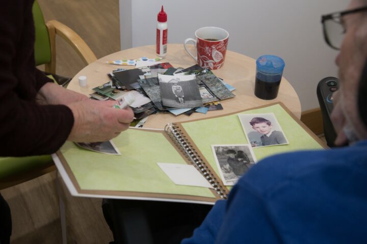 Scrapbook and photos with a man looking at them