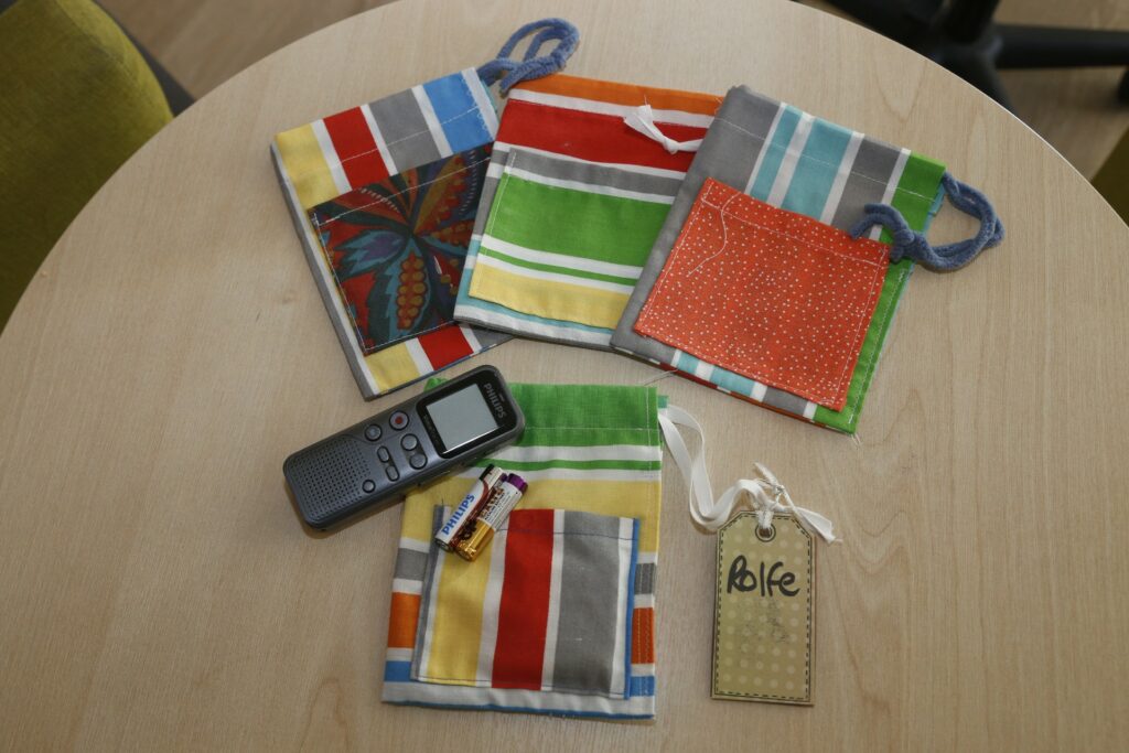 Colourful handmade bags and recorder and batteries on a table 