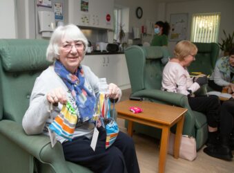 Female sitting in a chair holding handmade bags