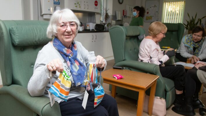 Female sitting in a chair holding handmade bags
