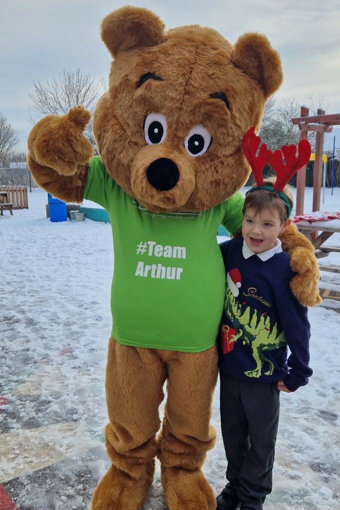 Life sized bear and boy with red anters in the snow 