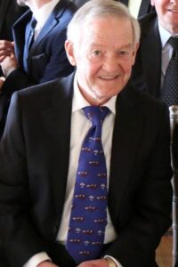 Male wearing suit and tie smiling at the camera