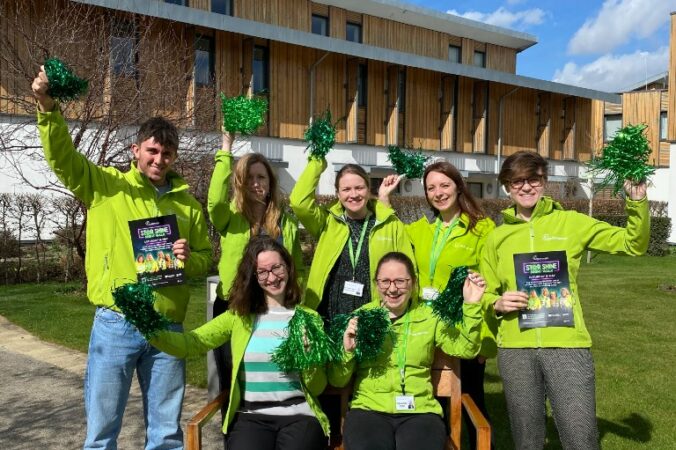 Group of males and females wearing green tshirts