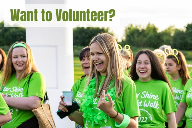 Females wearing green t-shirts walking and smiling