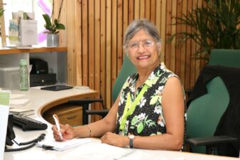 female sitting behind a desk smiling at the camera