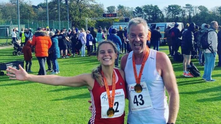 young lady with father (older male) wearing running medals