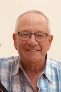 Man wearing glasses and checked shirt smiling at the camera