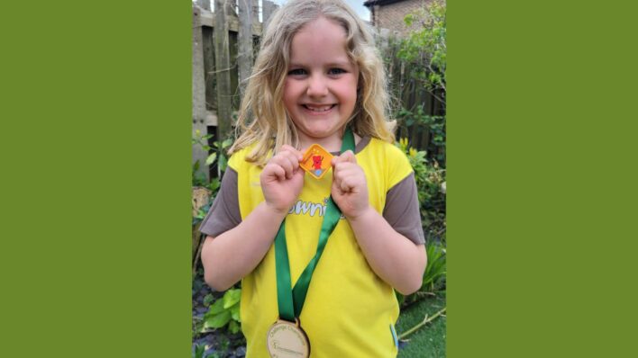 Young girl in brownie uniform & Team Arthur medal