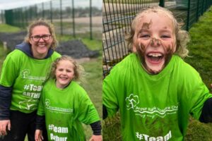 young supporter covered in mud and girl with her mum in TeamArthur Tshirt