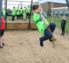 Young male in green tshirt swinging on a rope