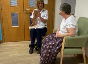 2 females sitting in chairs with leg compression hosiery