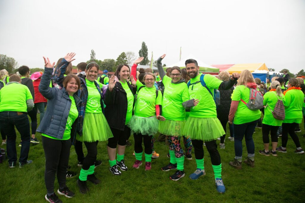 males and females dressed in green tshirts smiling in a group